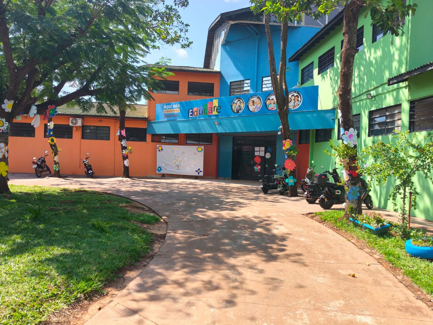 Fachada colorida do Colégio Educare Arco-Íris, com entrada decorada